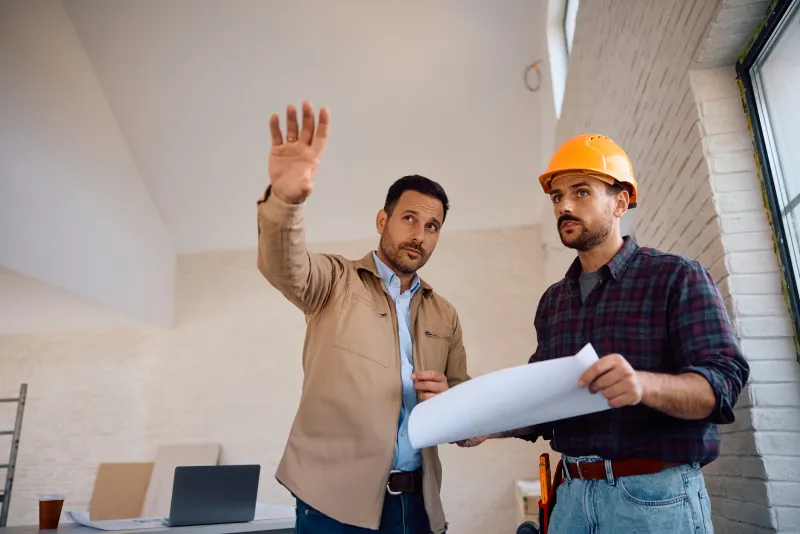 Contractor and owner reviewing blueprints